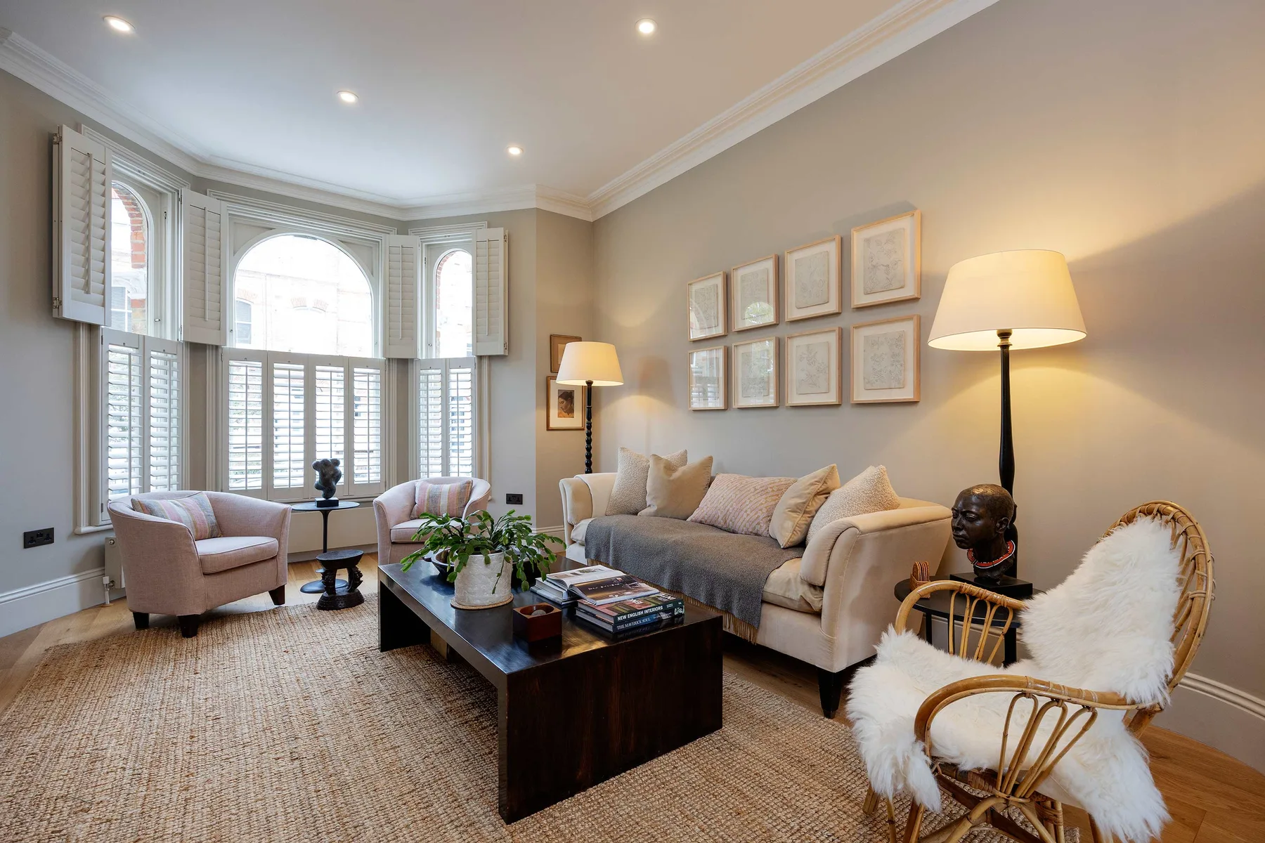 A bright living room with seating arranged around a coffee table and large windows.