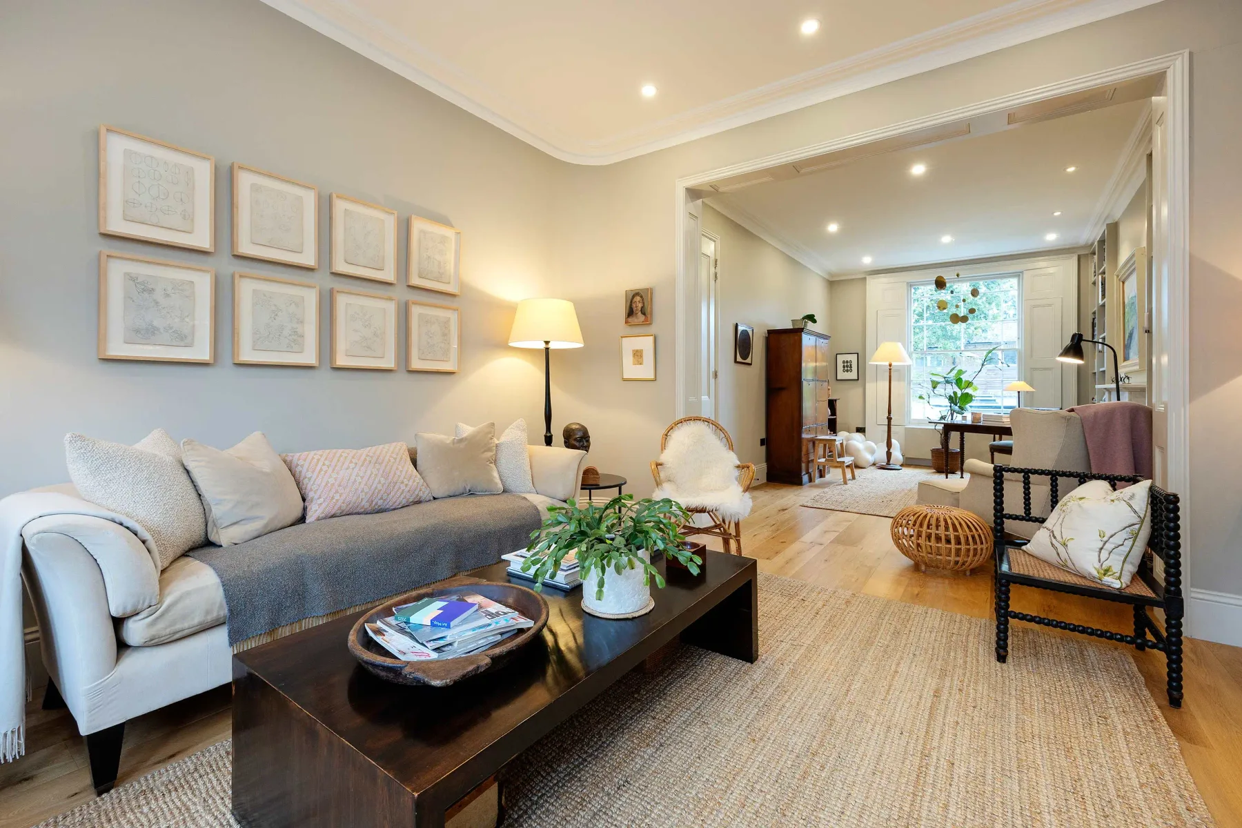A bright living room with seating, framed artwork, and a low coffee table.