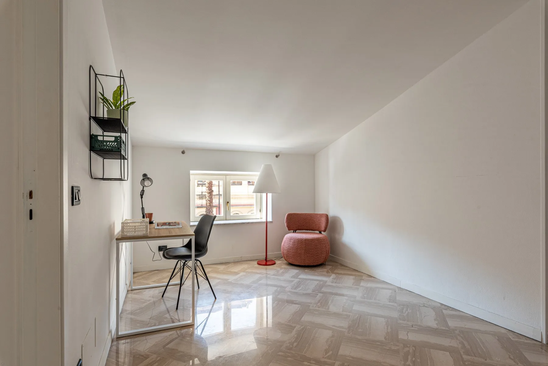 Una habitación luminosa con escritorio, asientos y una ventana amplia.