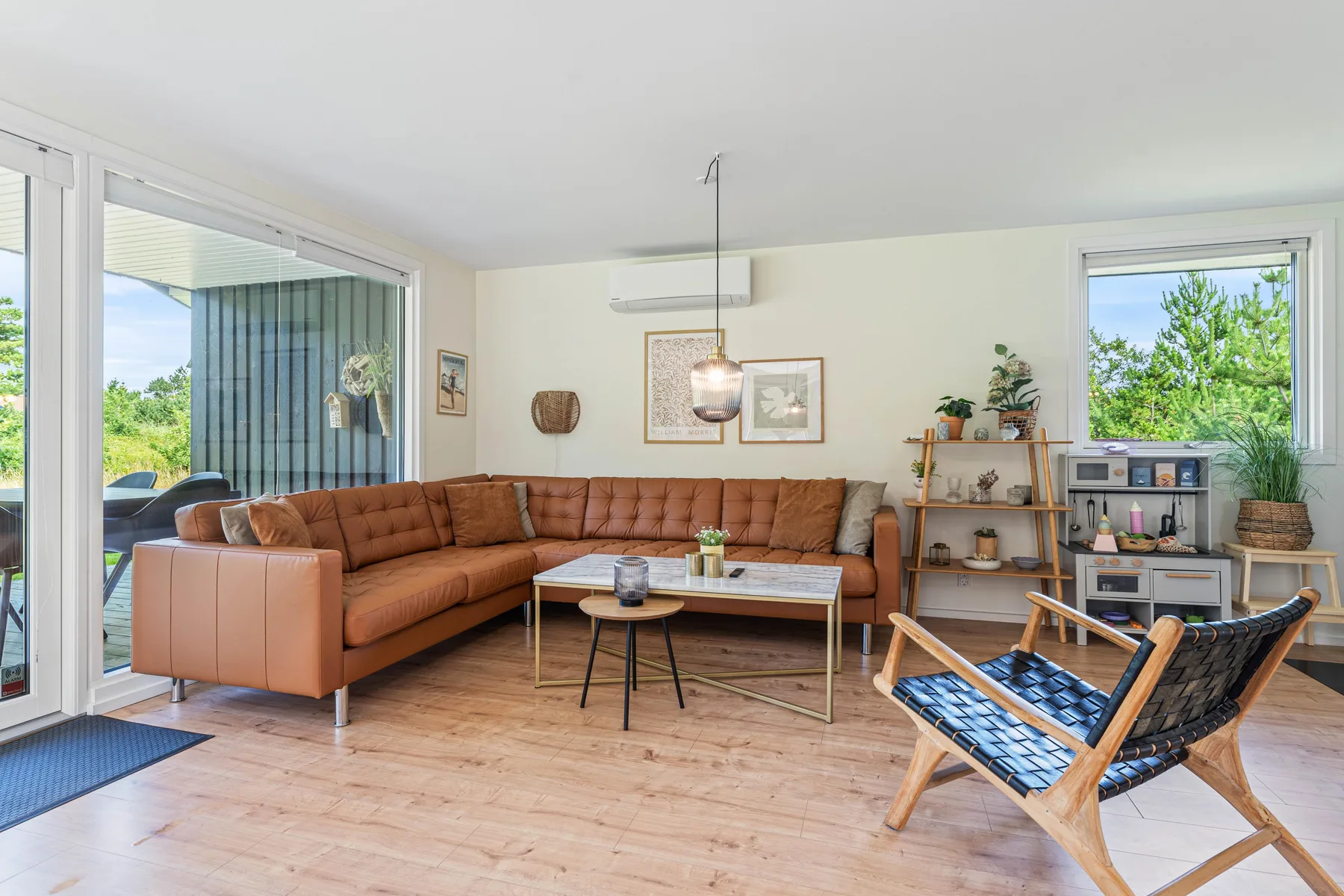 Una sala luminosa con asientos alrededor de una mesa de centro junto a grandes ventanas.