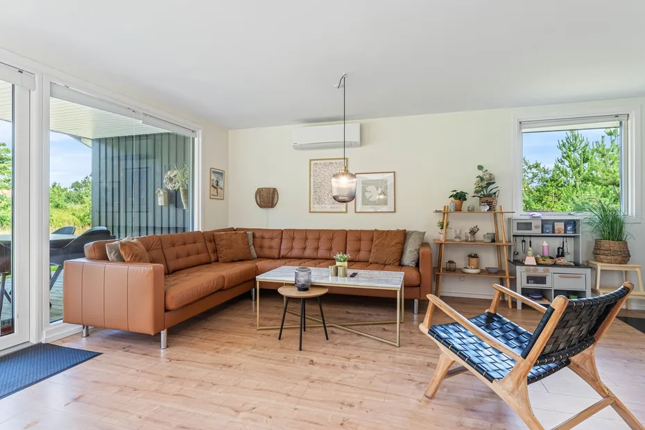 Una sala luminosa con un sofá en forma de L y una mesa de centro de vidrio.