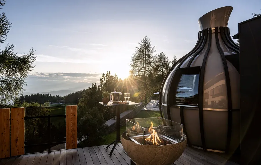 Hotel terrace with fireplace and mountain view.