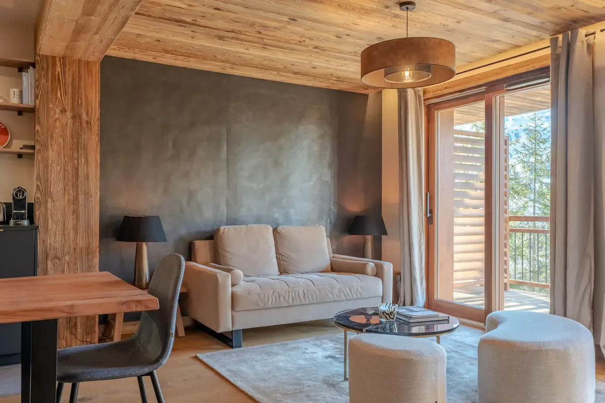 Una sala de estar con un sofá y grandes ventanas que dan a un balcón.