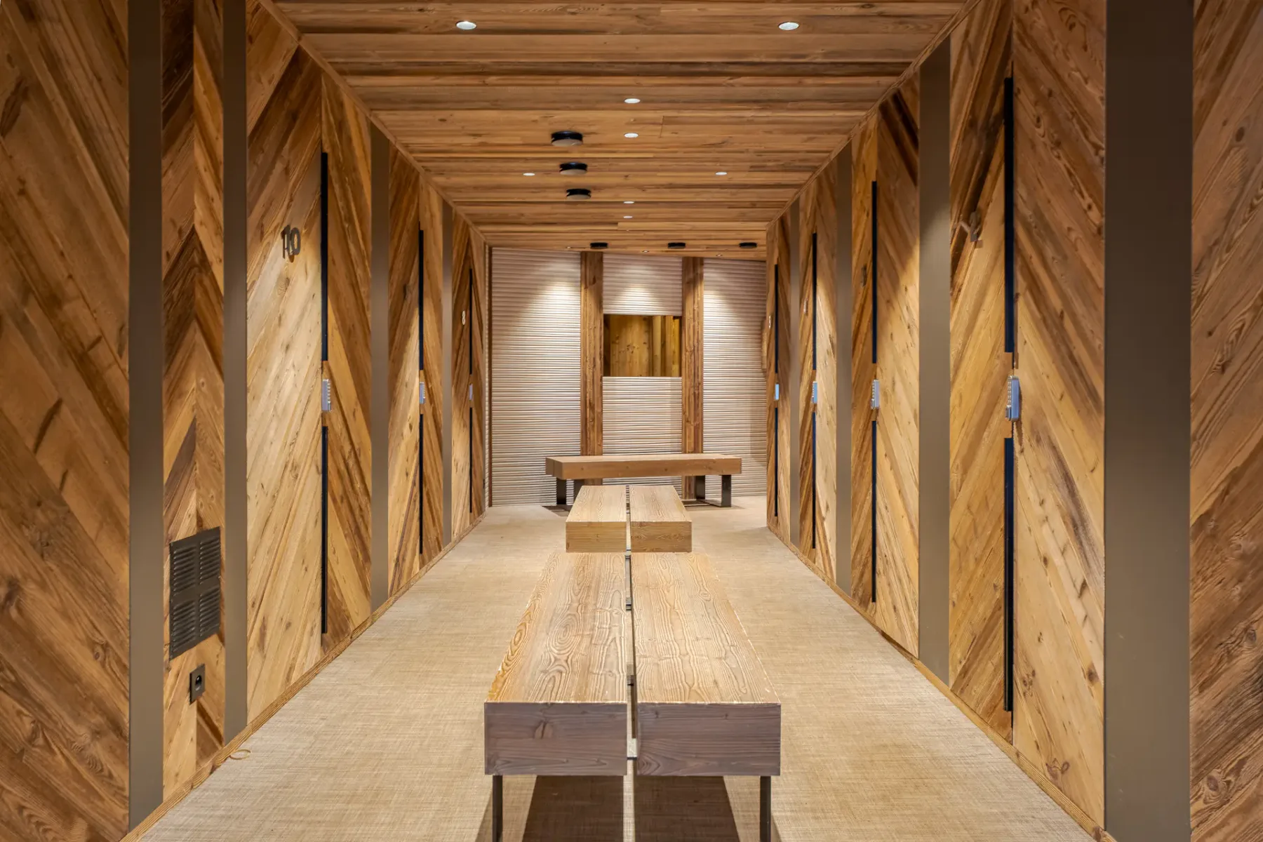 Pasillo revestido de madera con bancos y techo de madera.
