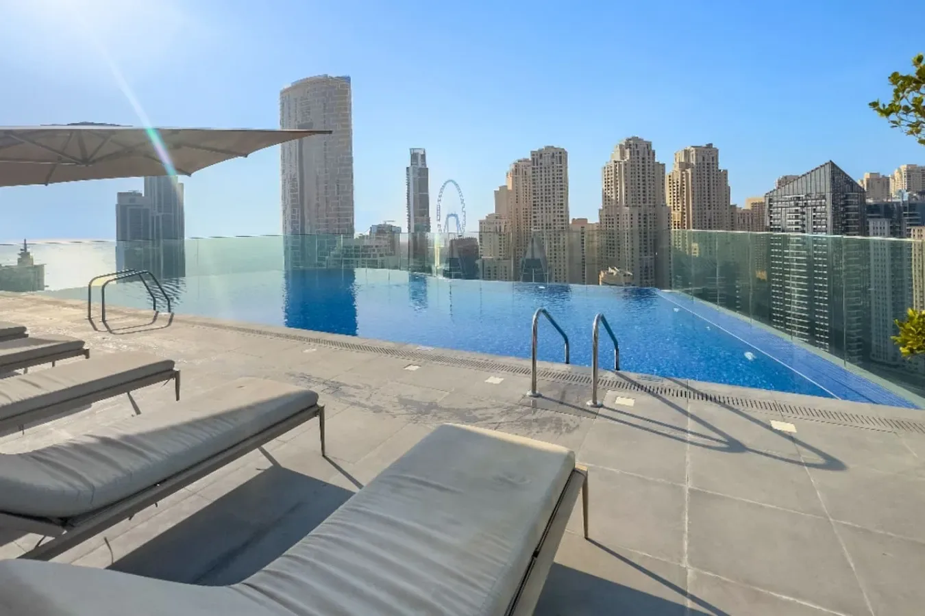 Una piscina en la azotea ofrece vistas del horizonte urbano, con asientos junto a la terraza.