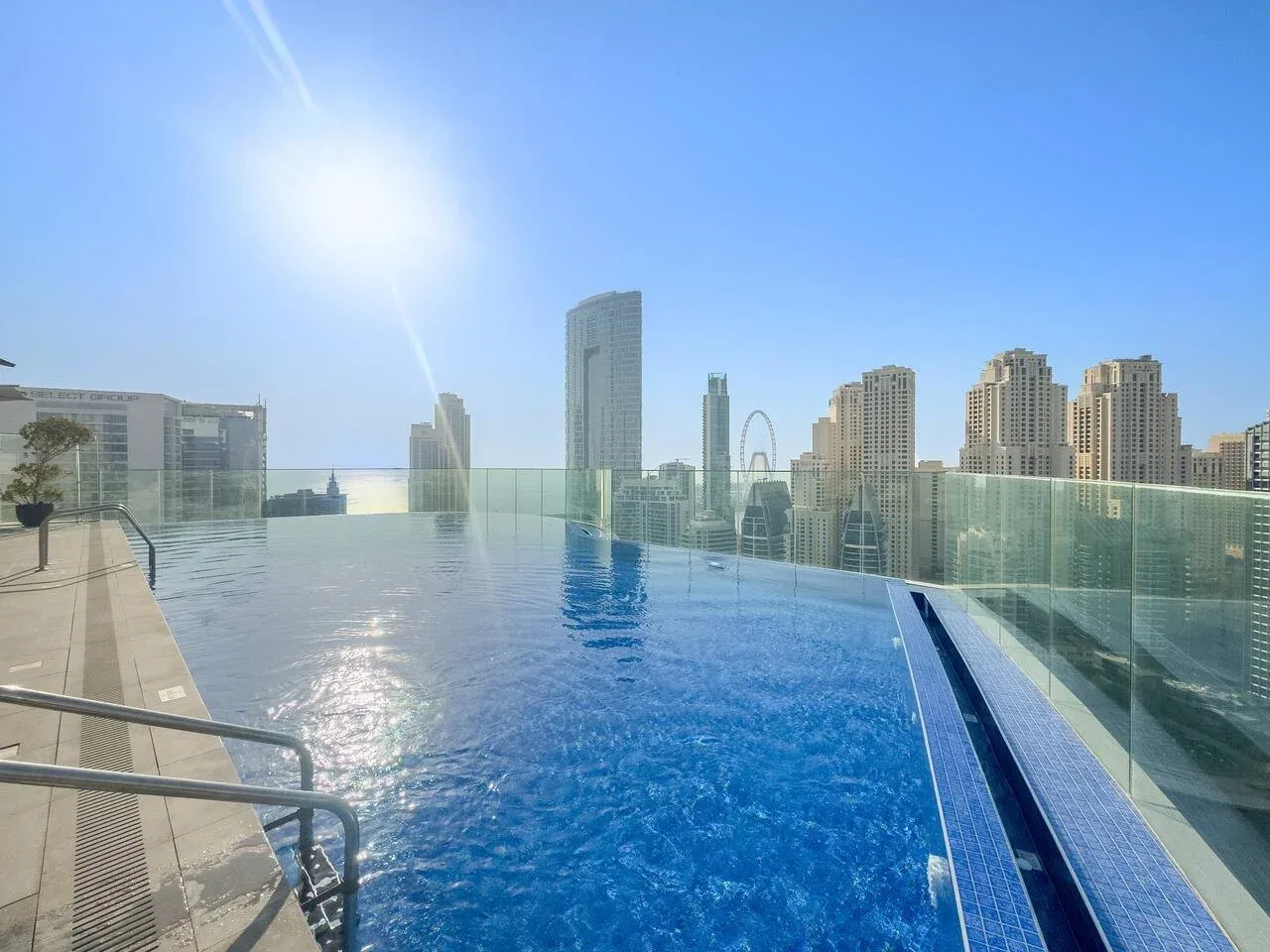 Una piscina en la azotea ofrece vistas del horizonte urbano bajo un cielo despejado.