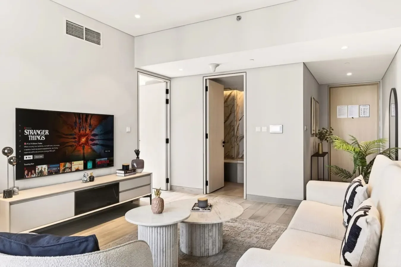 Una sala de estar luminosa con asientos, un televisor y una mesa de centro.