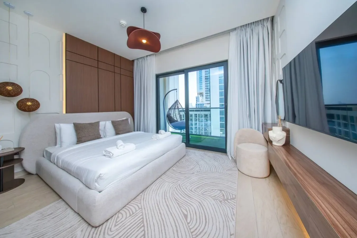 Un dormitorio con una cama, una ventana grande y una zona de descanso.