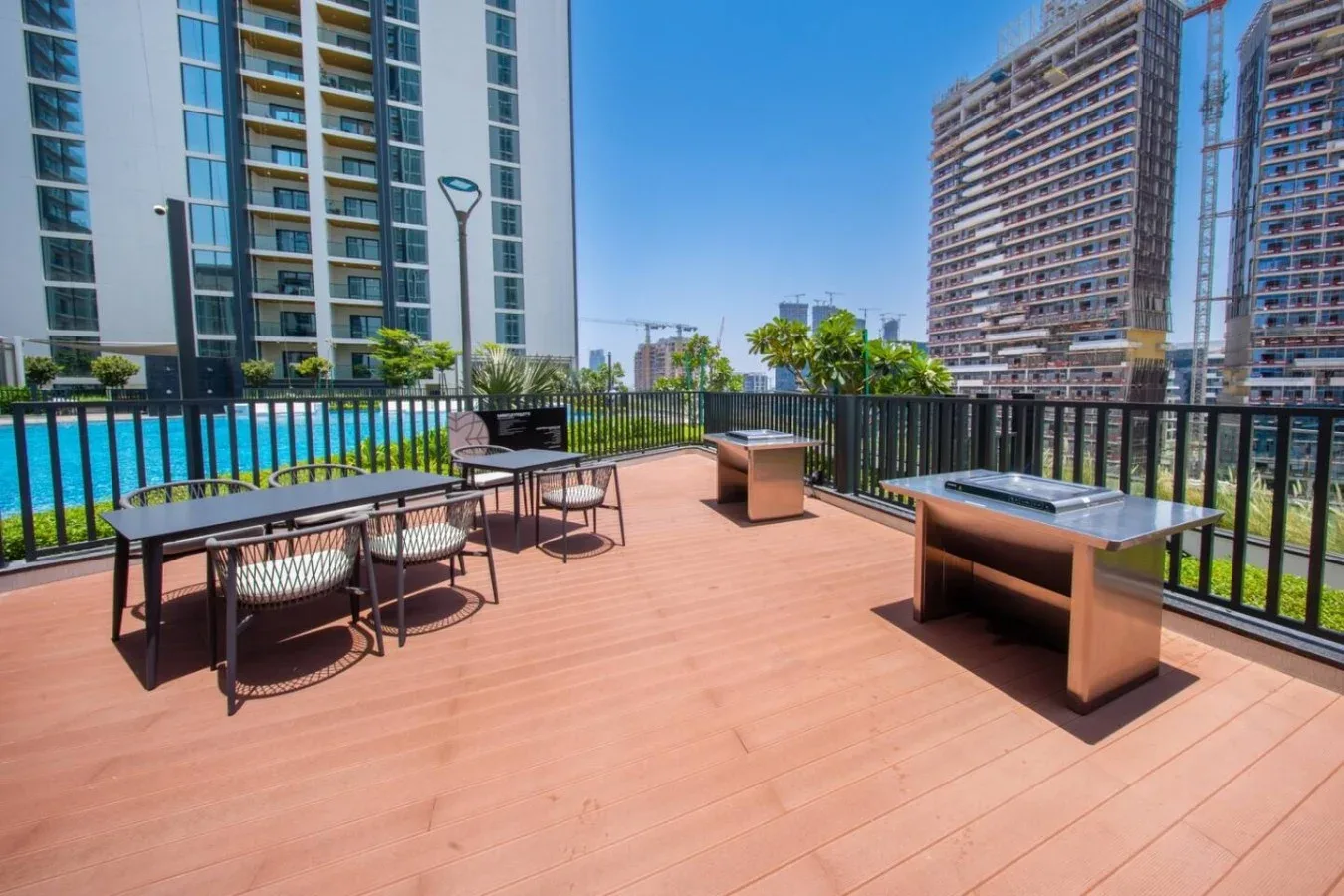 Una terraza en la azotea con asientos al aire libre y una piscina cercana.