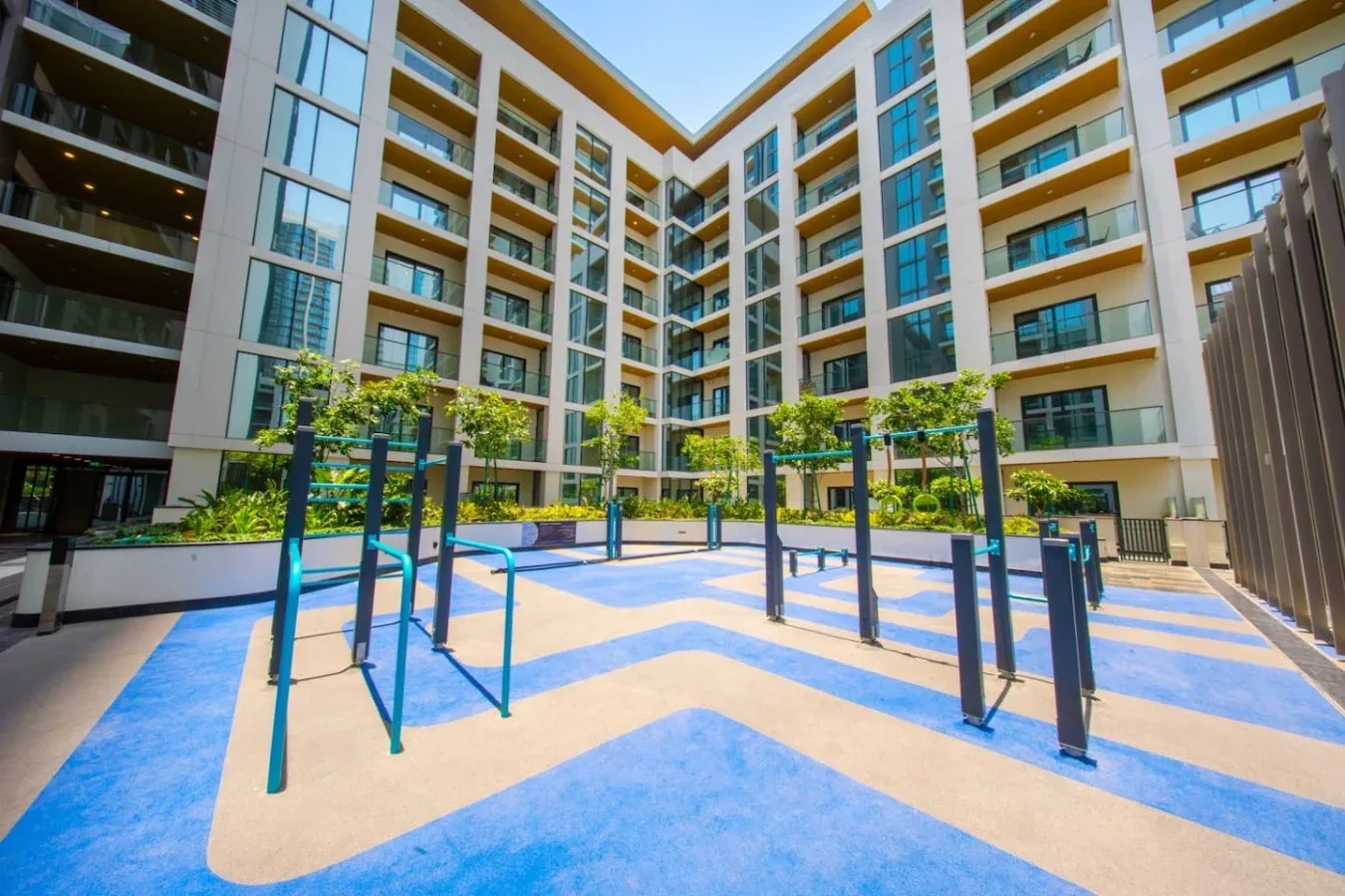 Una zona de ejercicio al aire libre se encuentra en el patio de un edificio de varios pisos.