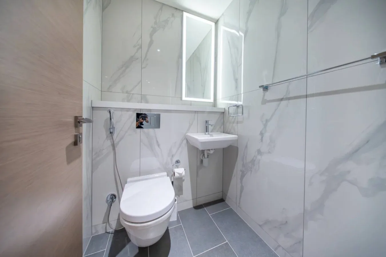 Un baño con azulejos, inodoro, lavabo y mampara de ducha de vidrio.