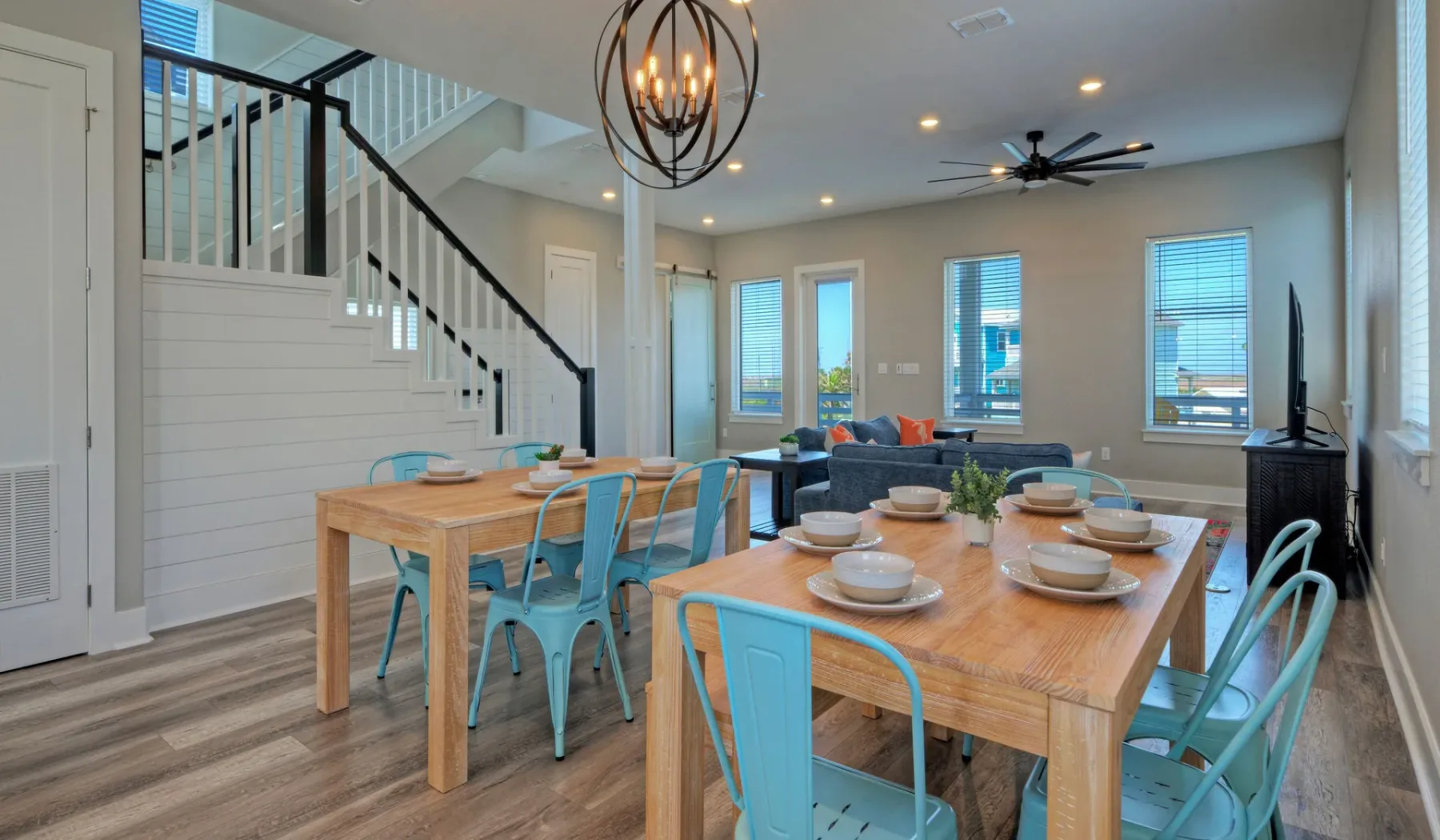 A dining area with wooden tables and blue seating beneath a hanging light.