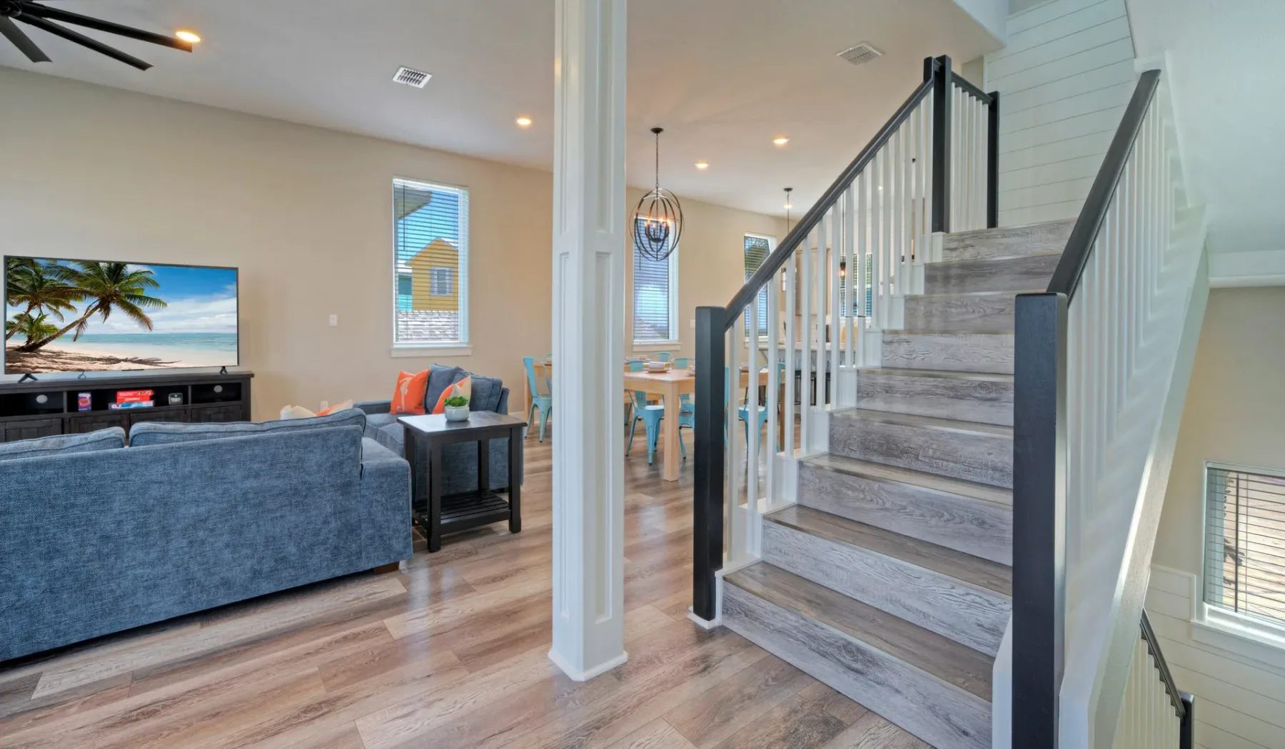 An open living area with seating, a television, and a staircase.