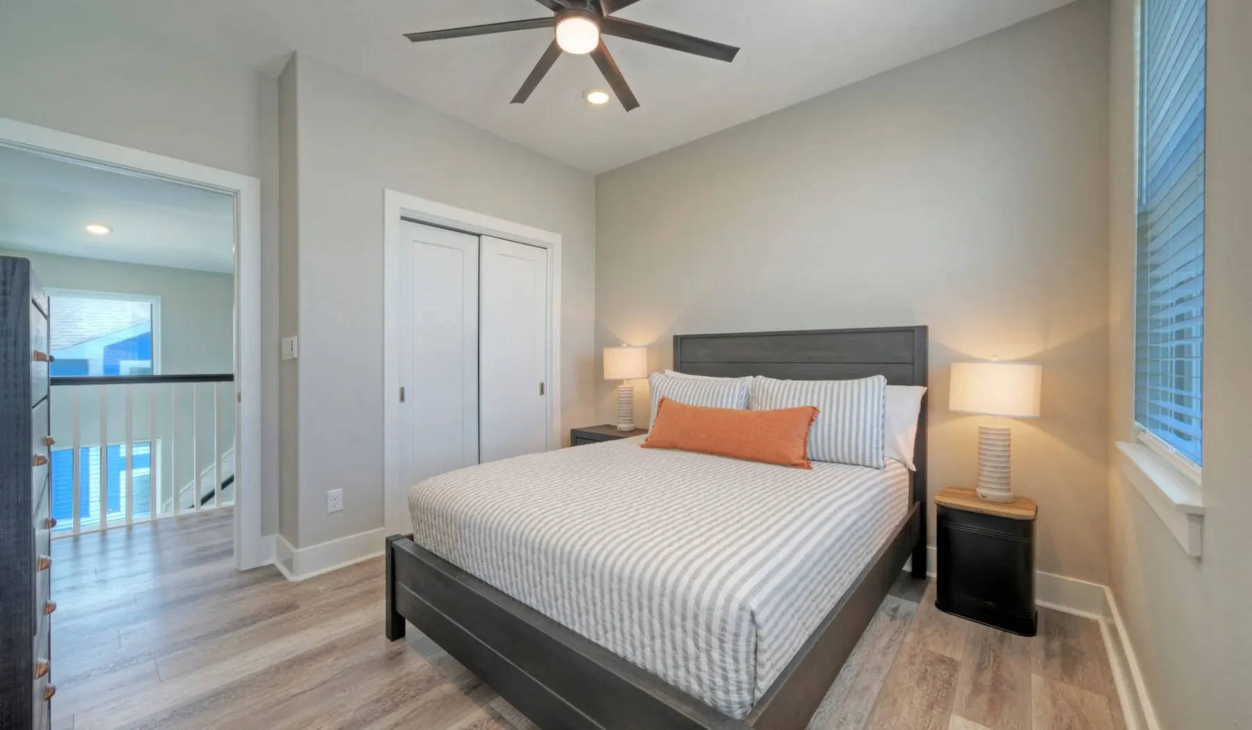 A bedroom with a neatly made bed and bedside lamps.