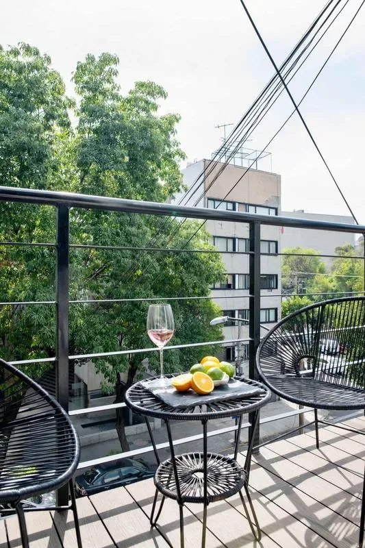 A balcony seating area with a small table and fruit beside the railing.