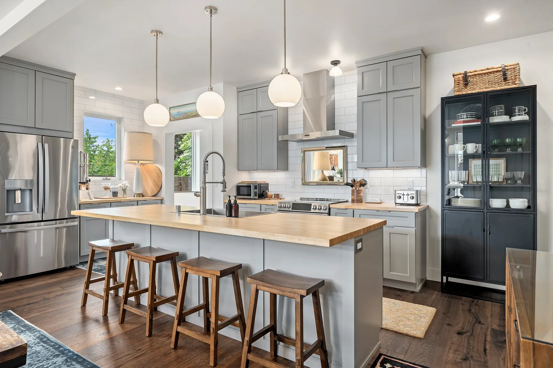 Una cocina luminosa con una isla grande y taburetes de madera.