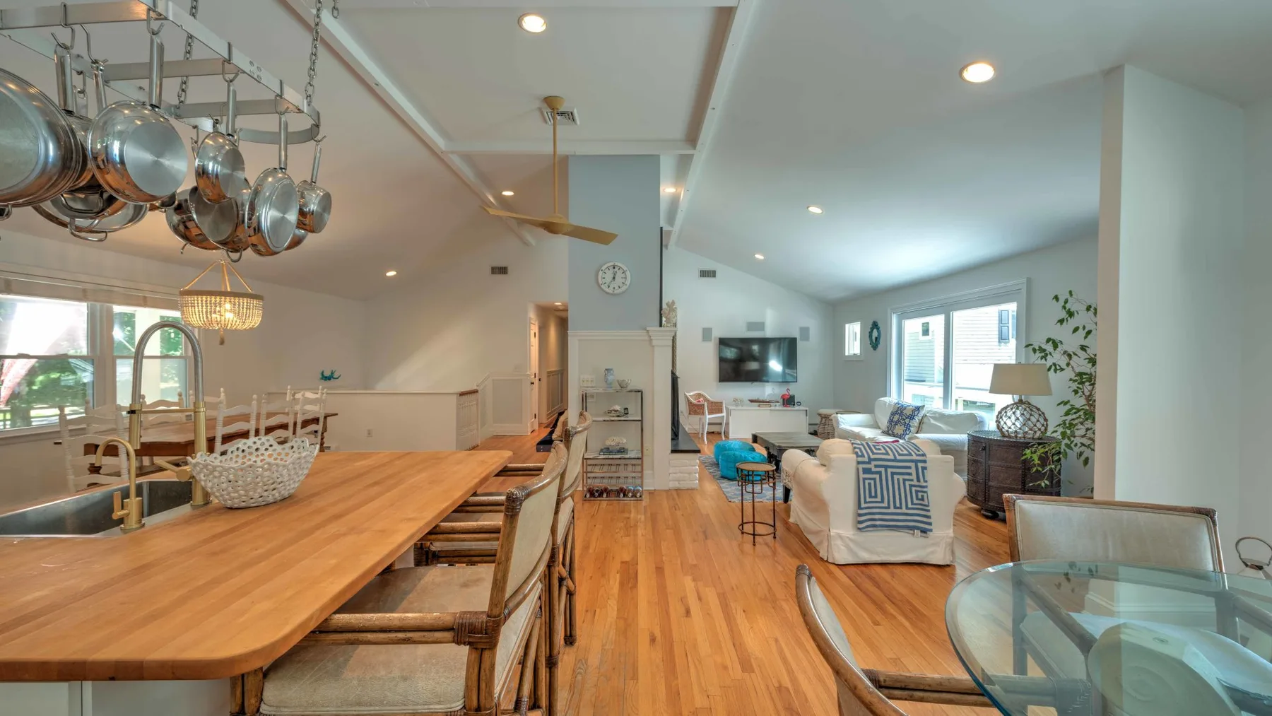 Cocina y sala de estar de planta abierta con una larga barra de madera y asientos.