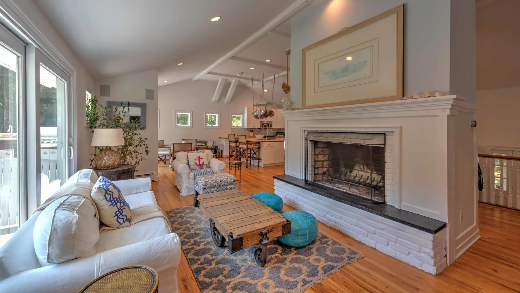 A bright living room with seating, a coffee table, and a fireplace.