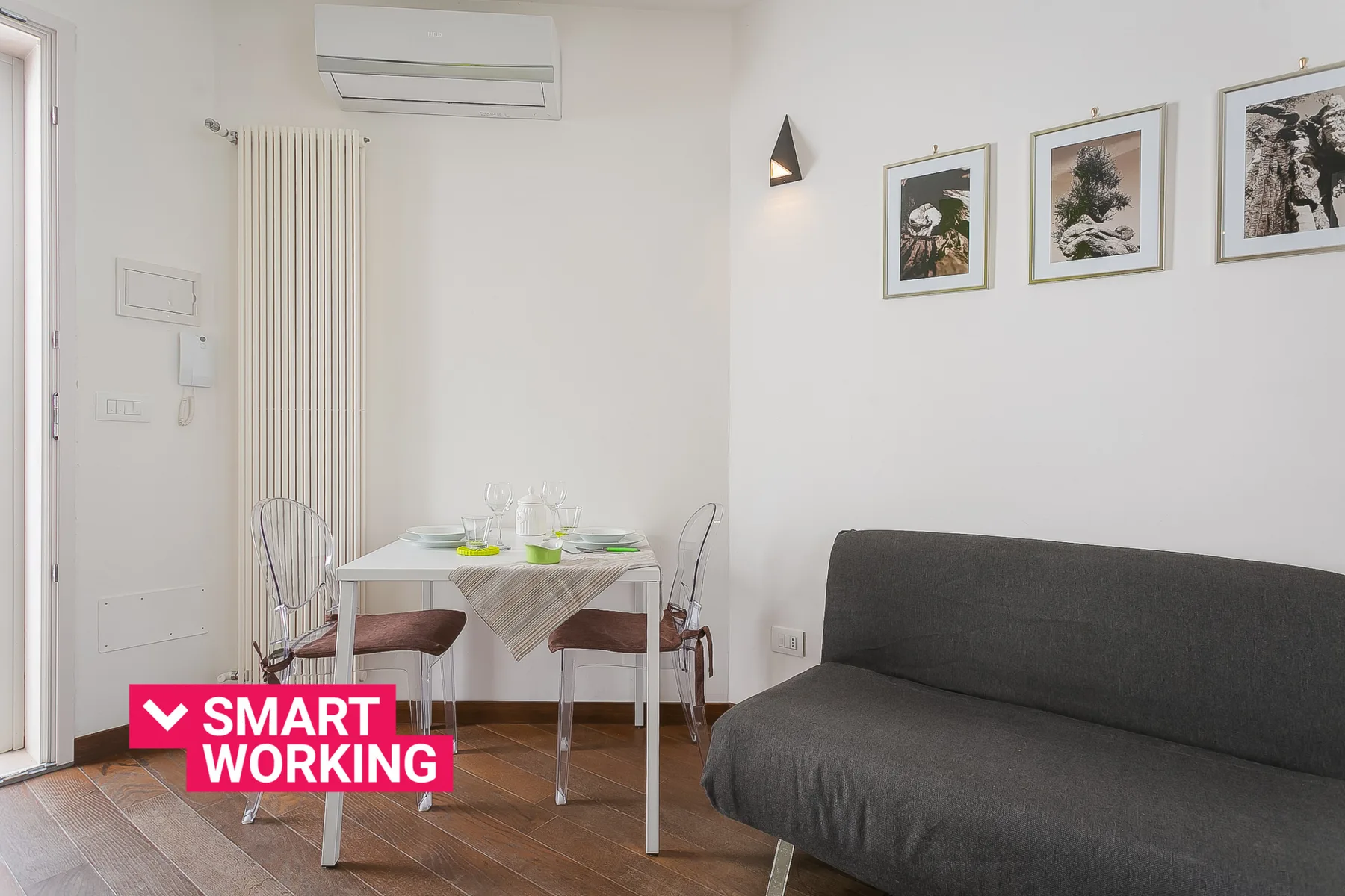 Una sala luminosa con una mesa de comedor y asientos oscuros.