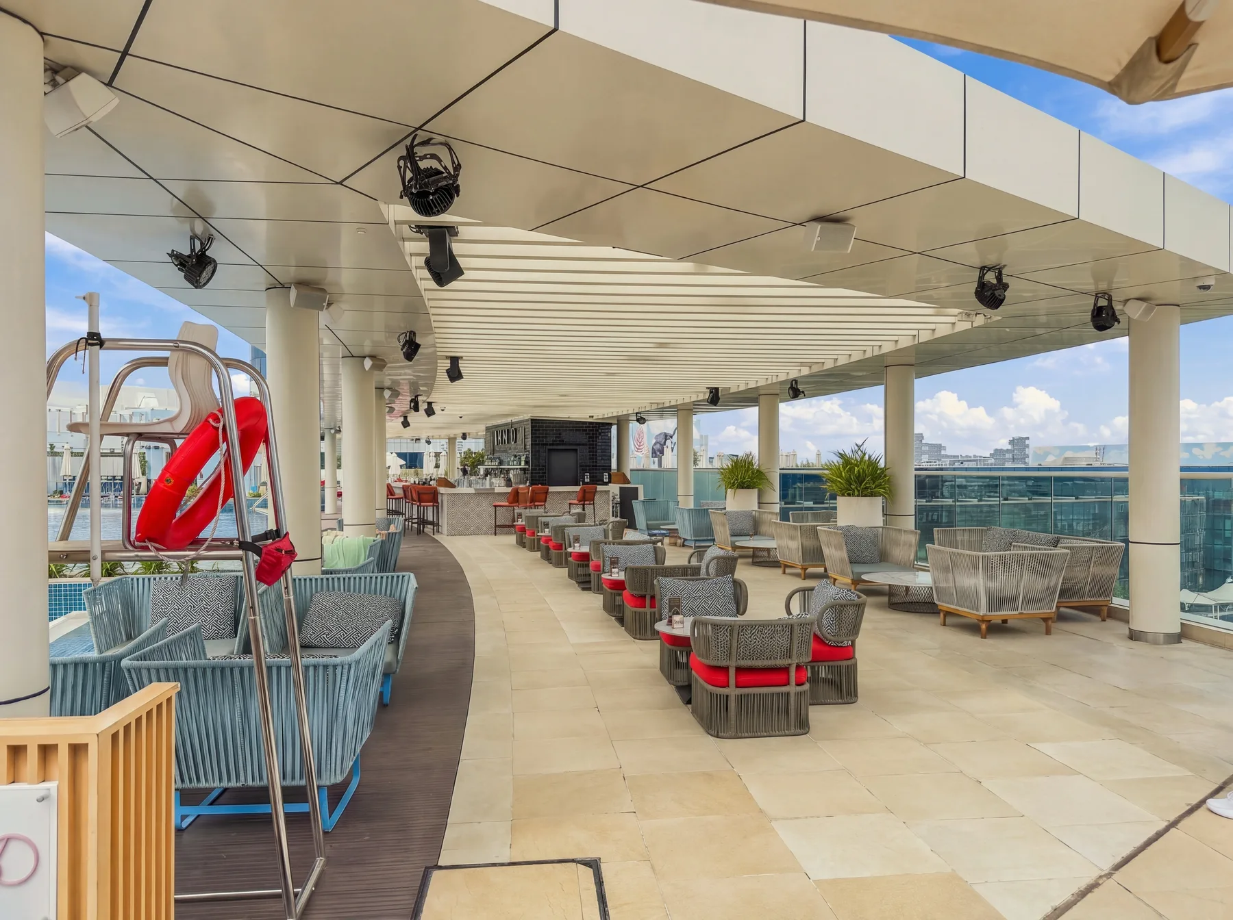 Una terraza en la azotea con asientos al aire libre y una piscina.
