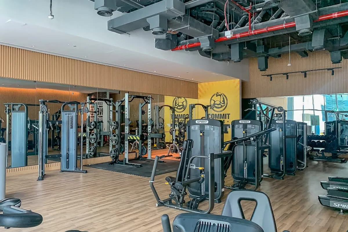 Un gimnasio con máquinas de pesas y equipo de ejercicio distribuido por la sala.