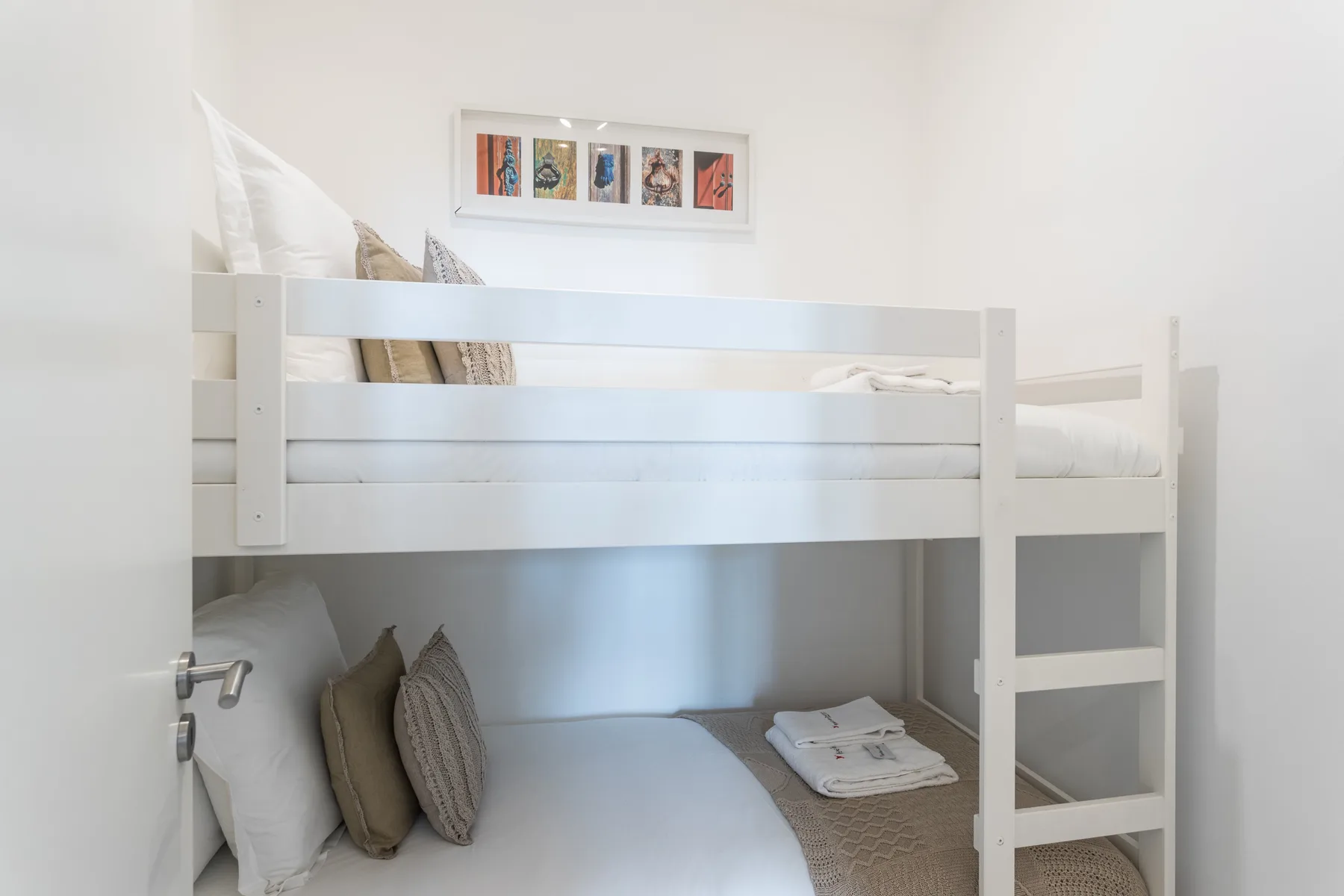Una zona compacta para dormir con una litera y cuadros enmarcados encima.