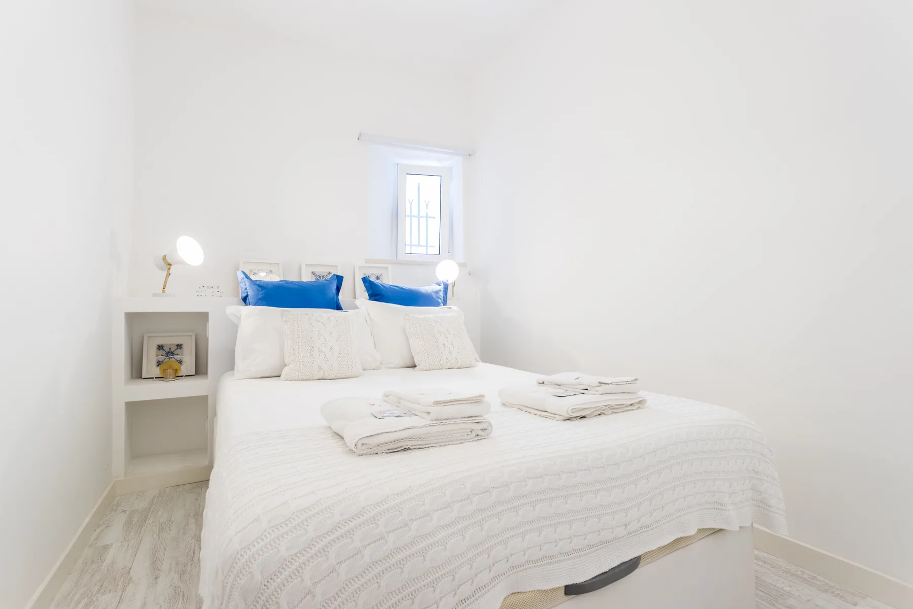 Un dormitorio luminoso con una cama bien hecha y toallas dobladas.