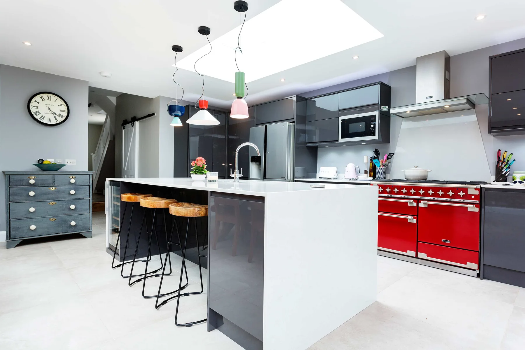 A modern kitchen with a central island and red cabinets.
