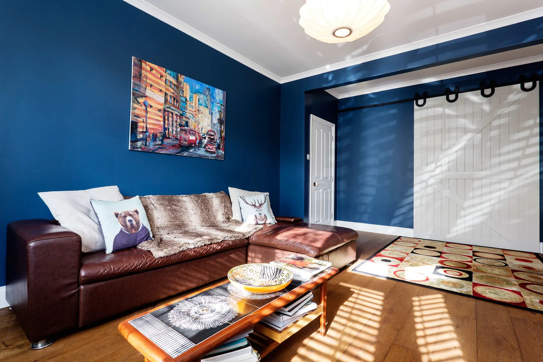 A living room with seating, a coffee table, and blue walls.
