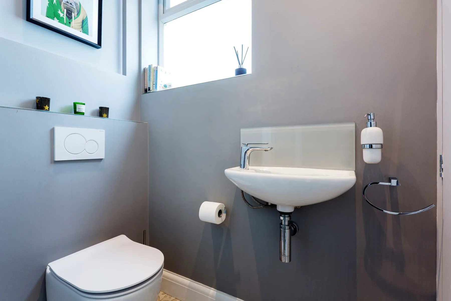 A compact bathroom with a wall-mounted sink and toilet.