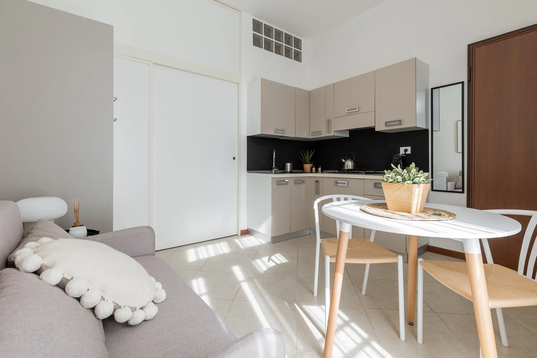 A bright living and dining area with a compact kitchen and table.