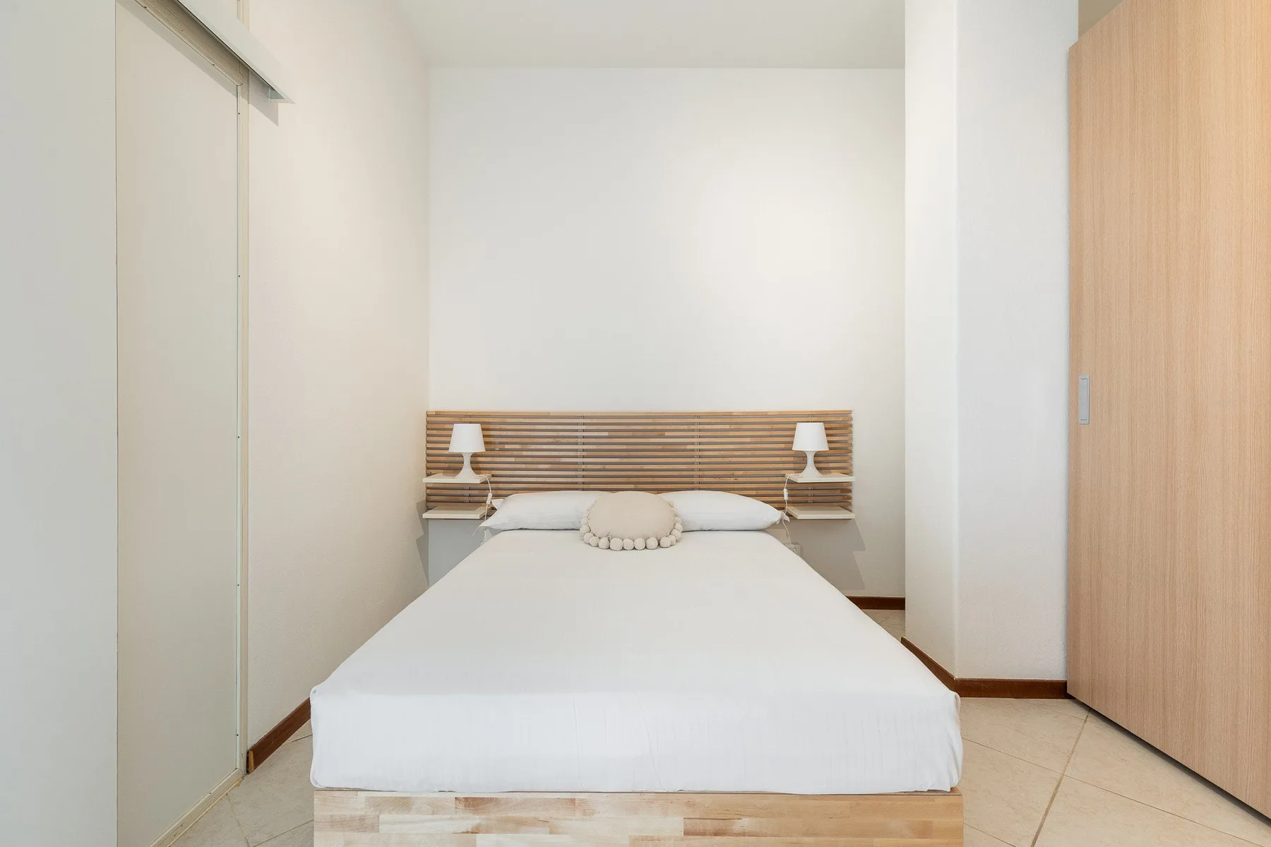 Un dormitorio con una cama y un cabecero de madera.