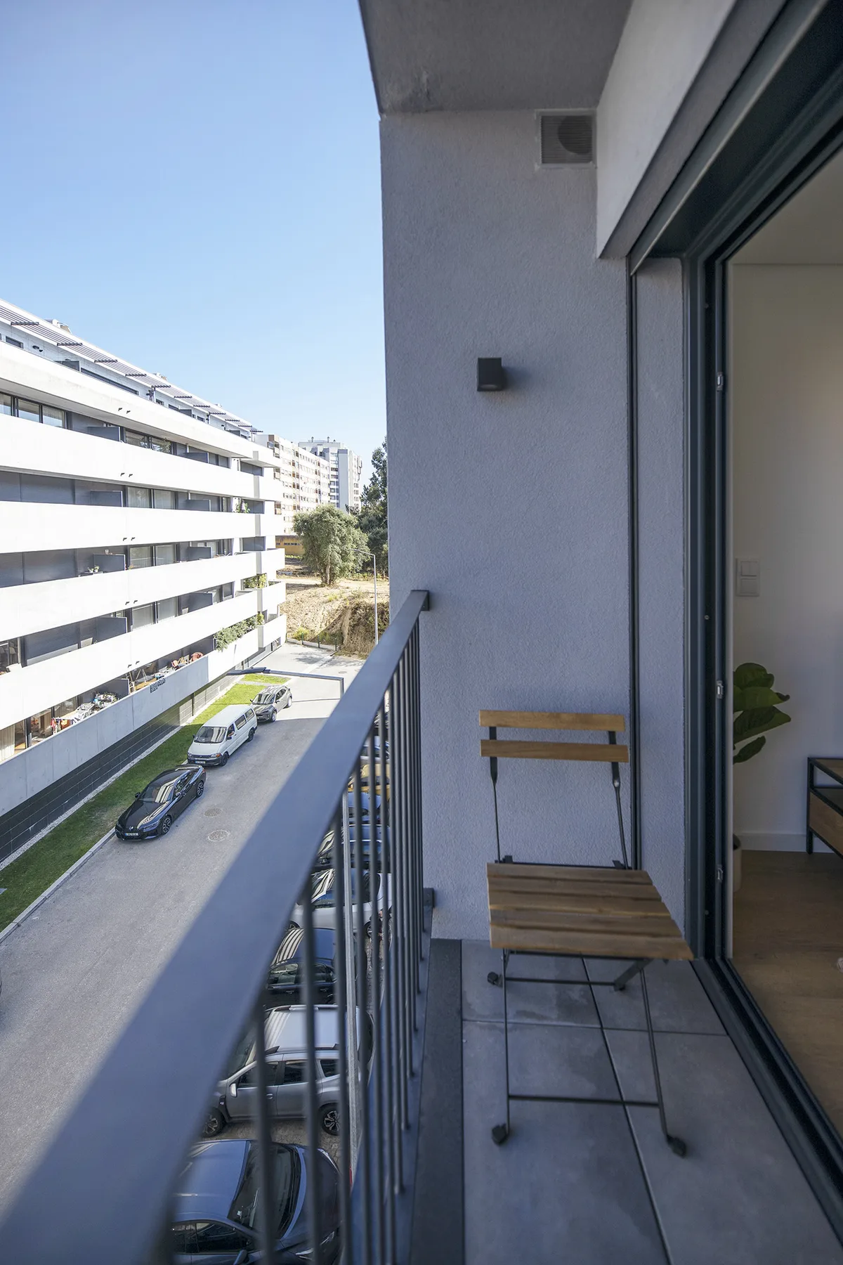Un balcón estrecho da a una calle y a edificios de apartamentos cercanos.