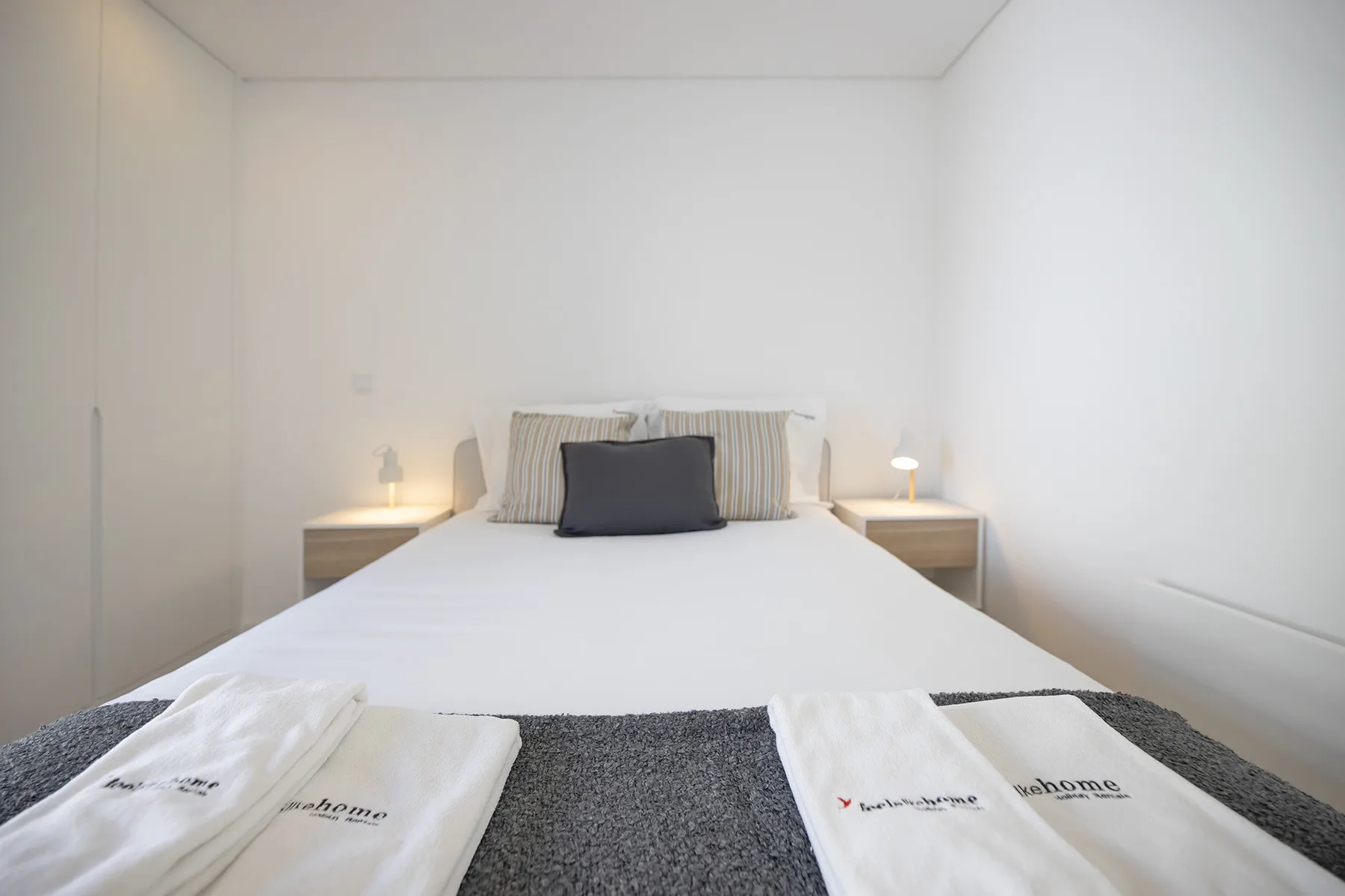 Un dormitorio con una cama bien hecha y mesas de noche.