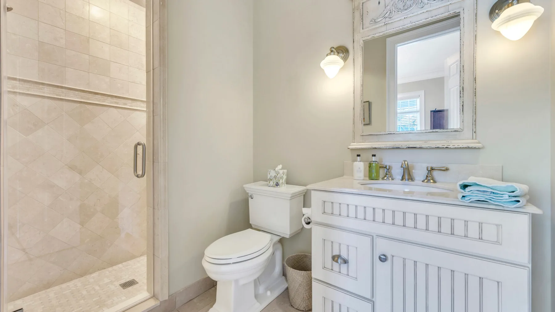 Un baño con ducha de vidrio, inodoro y lavabo.