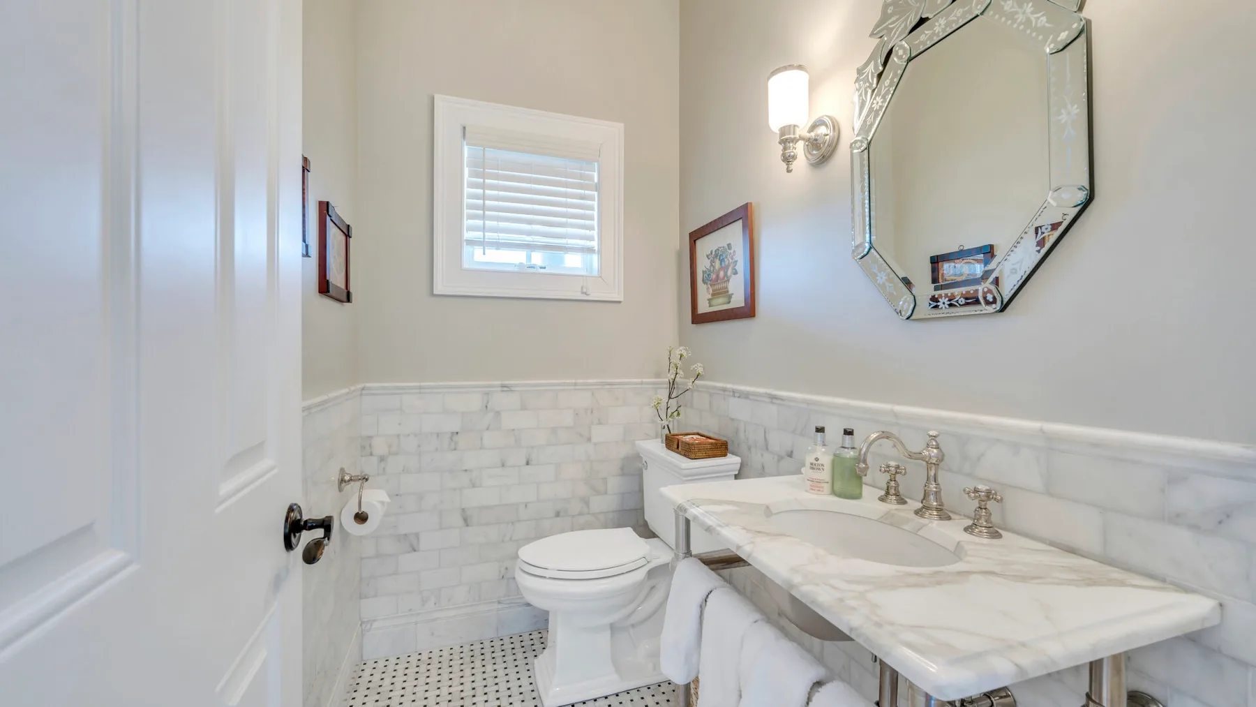 Un baño con un inodoro, un lavabo y un espejo de pared.
