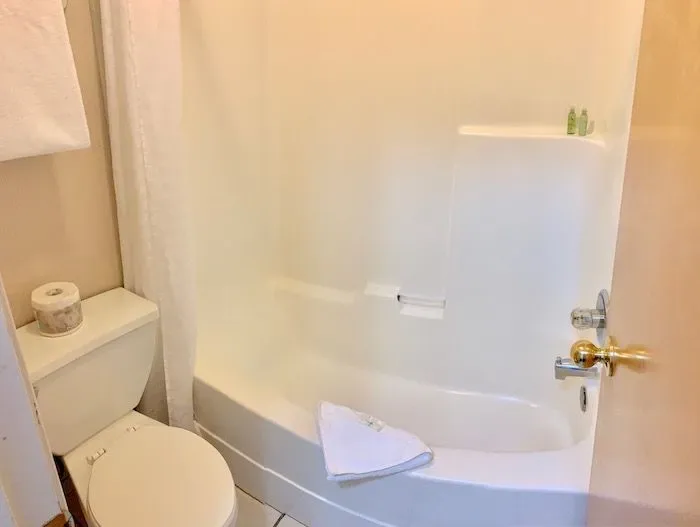 Private bathroom with bathtub and toilet.