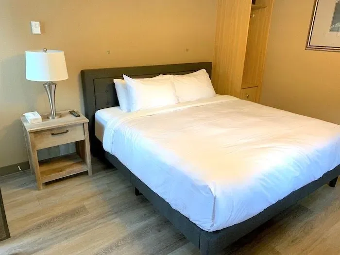 Guest room with a bed, nightstand and wardrobe.