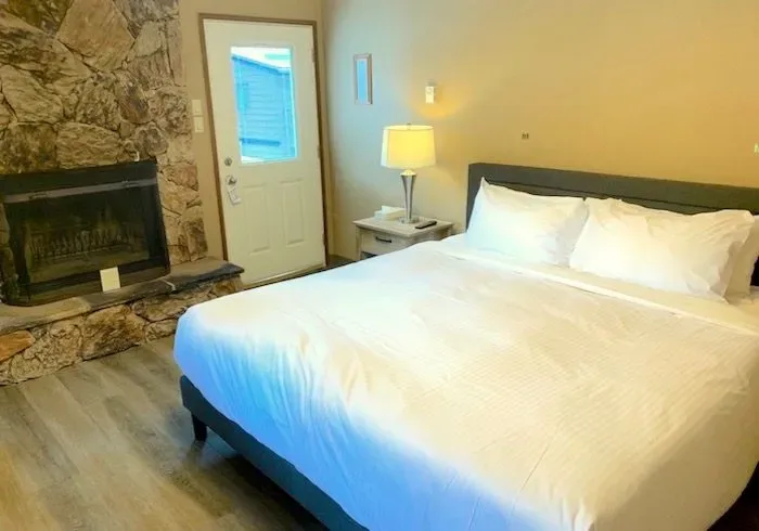 Guest room with a bed and fireplace.