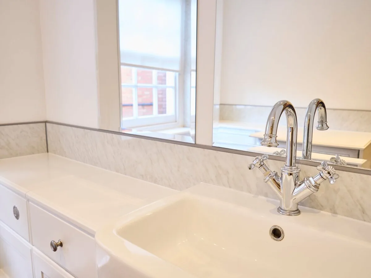 A bathroom vanity with a wide sink and a mirror above it.
