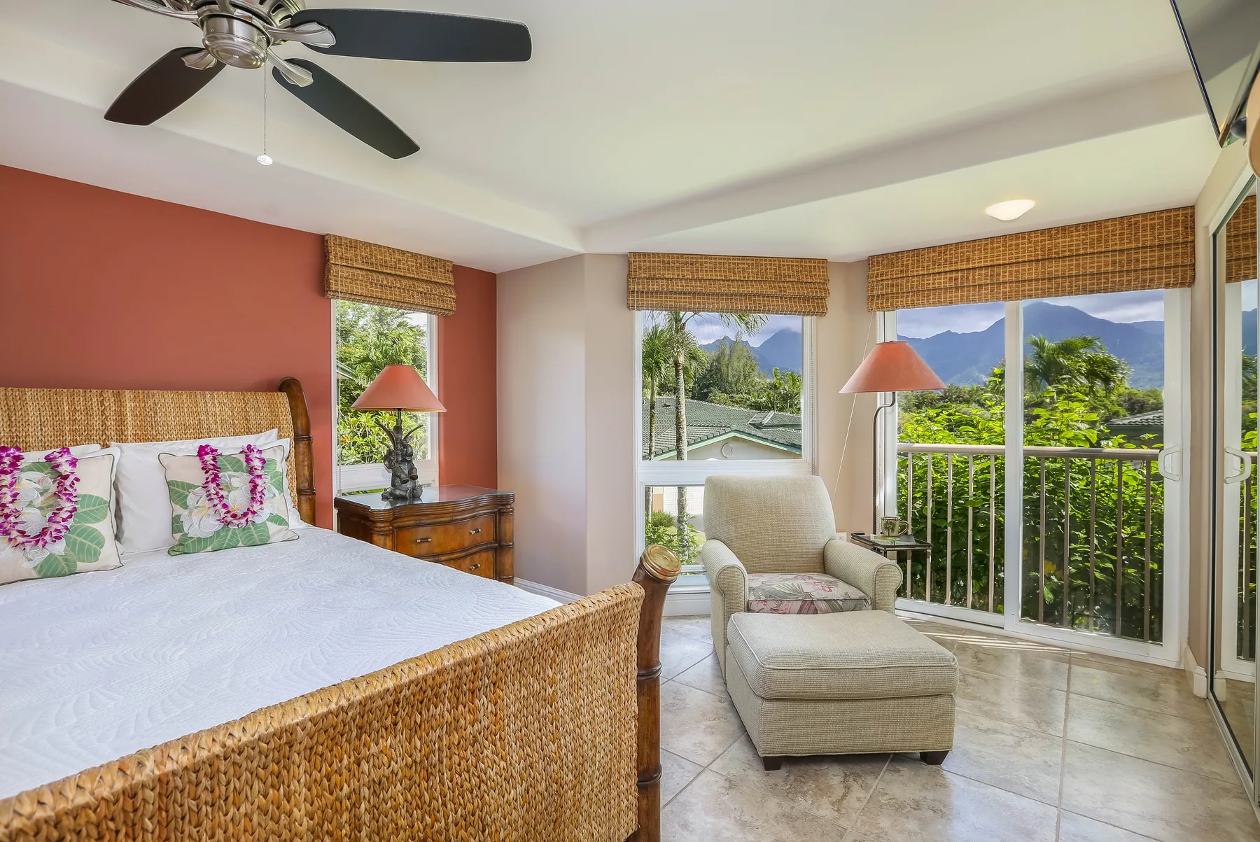 A bedroom opens onto a balcony with mountain views and a seating area.