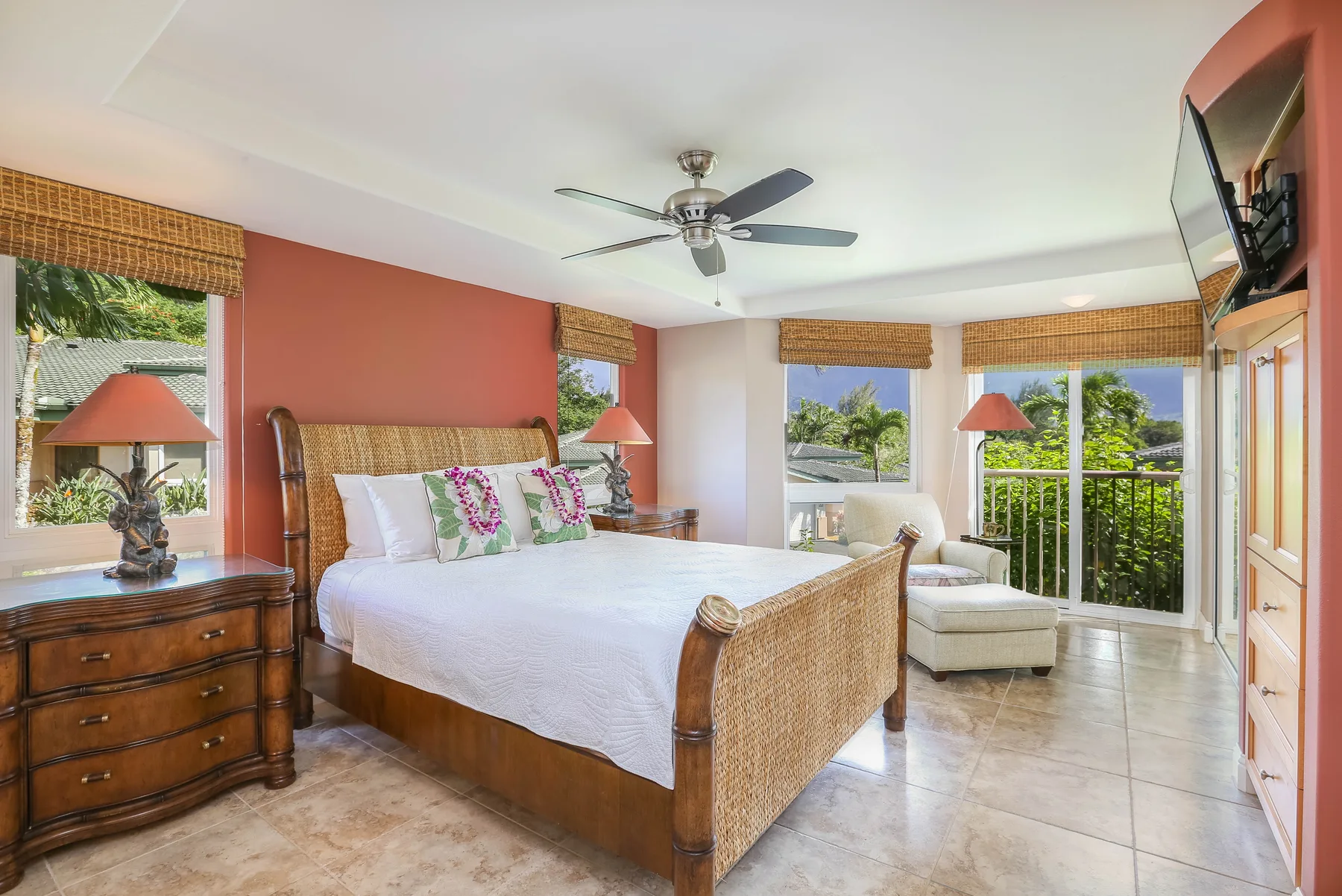 A bedroom with a large bed, bedside tables, and windows opening onto a balcony.