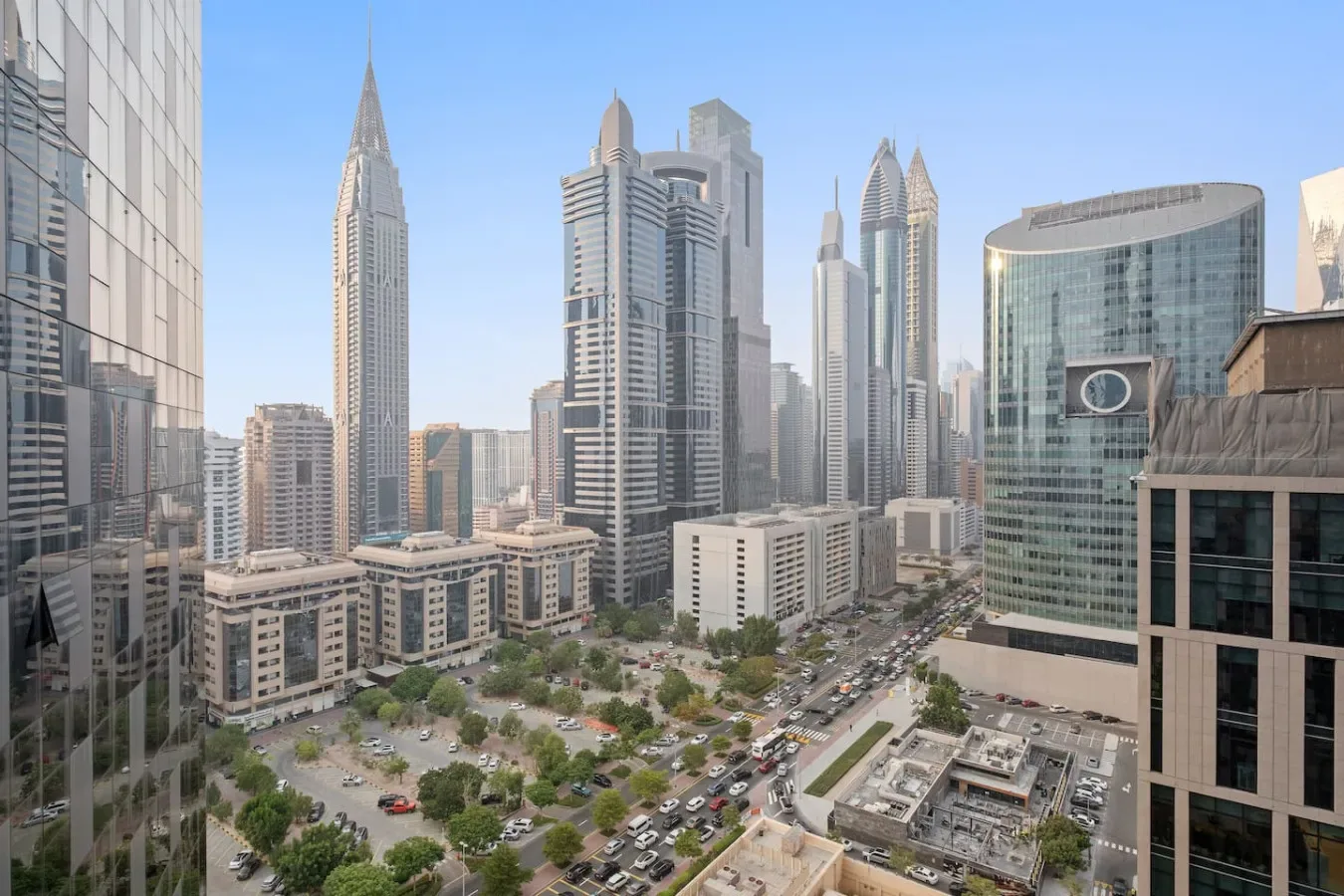Un horizonte urbano con edificios modernos y una carretera transitada en primer plano.