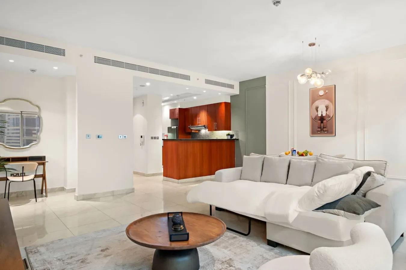 Una sala luminosa con asientos claros y una isla de cocina roja.