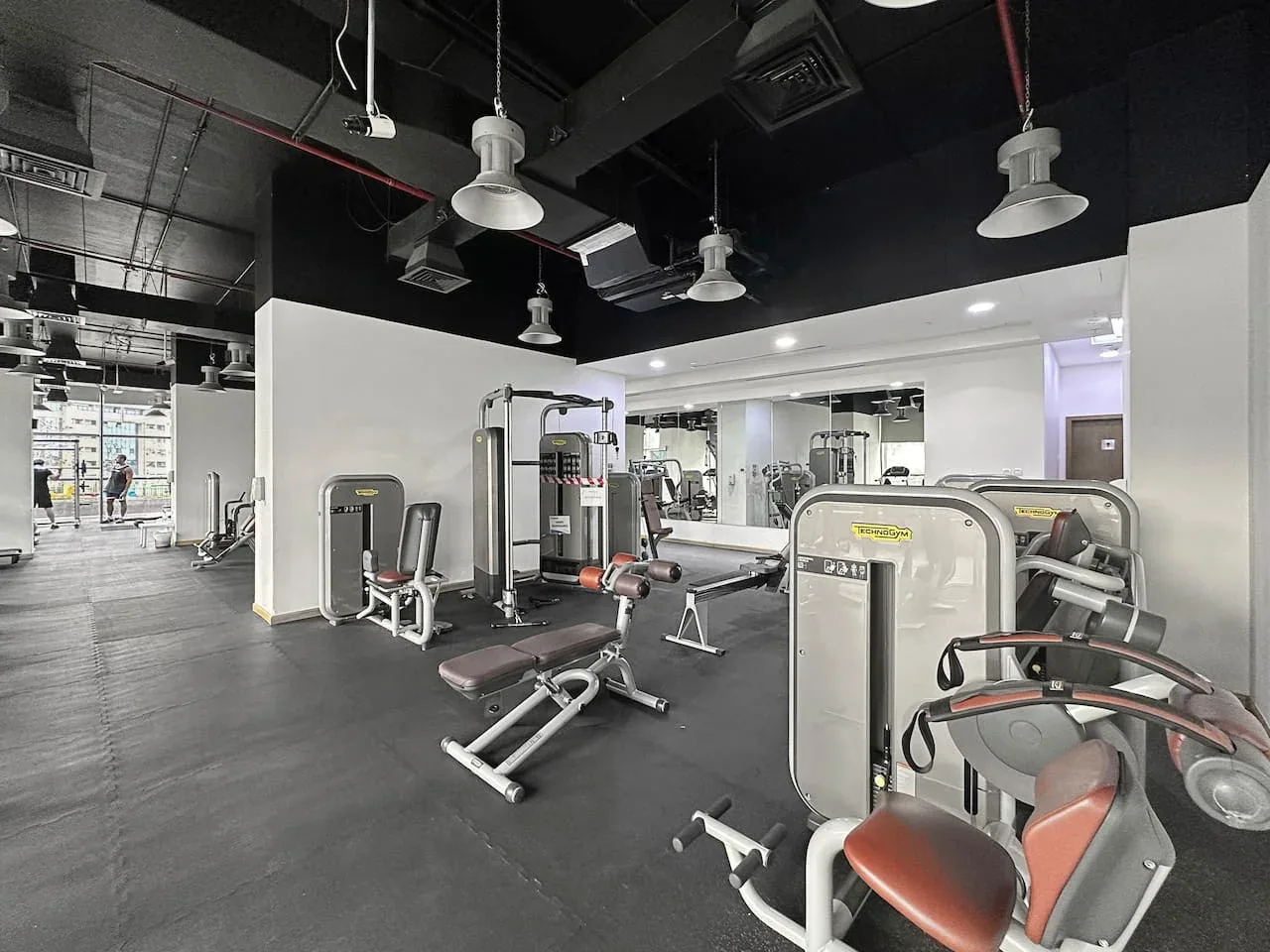 Un gimnasio con máquinas de ejercicio y bancos de pesas.