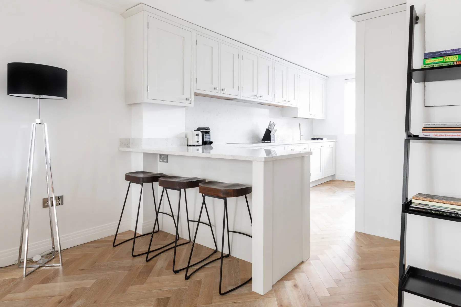 Bright kitchen with white cabinetry, a central island, and bar seating.