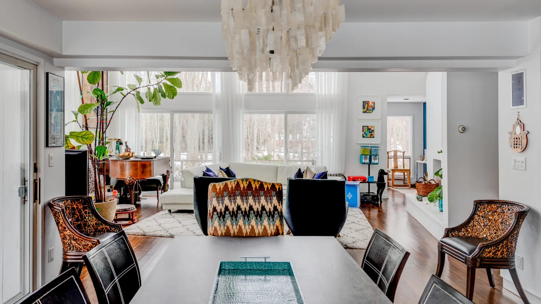 A bright living room with seating, a coffee table, and large windows.
