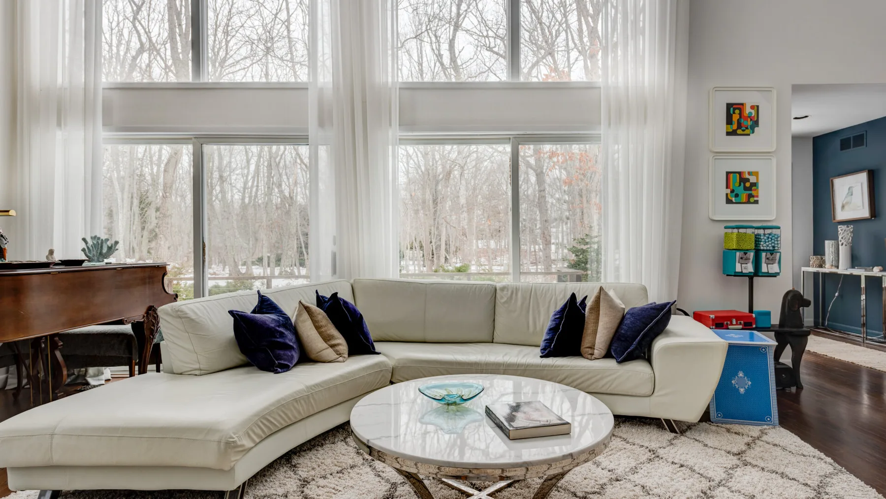 A bright living room with a sectional seating area and large windows.