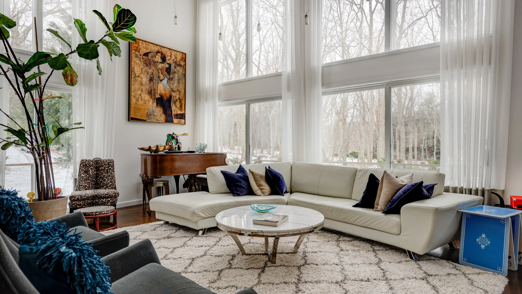 A bright living room with a sectional seating area and large windows.