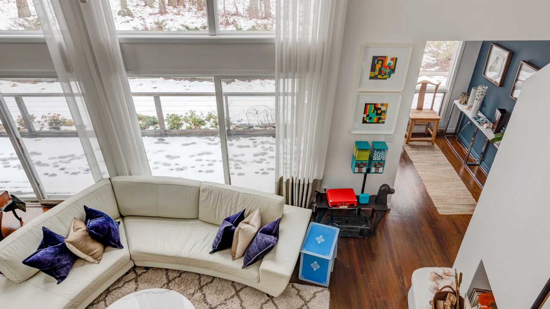A bright living room with curved seating beside large windows.